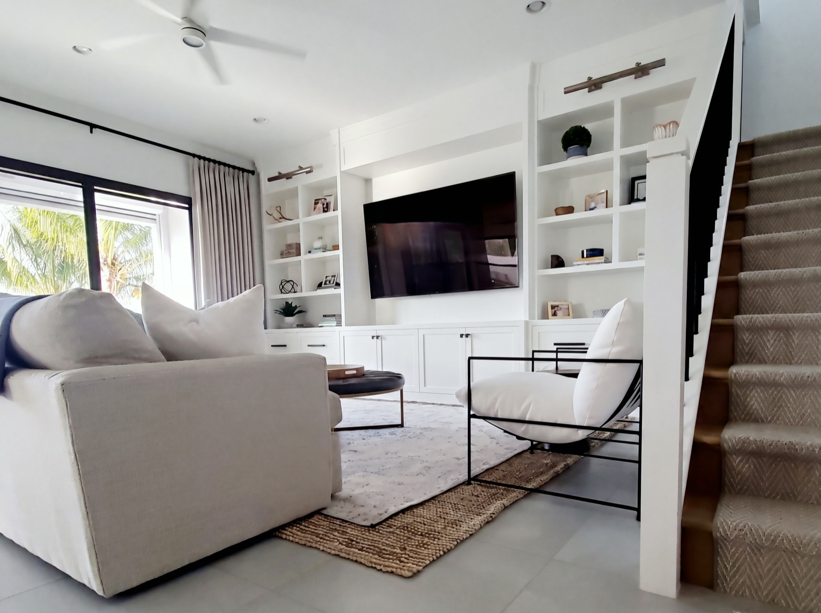 Family room with custom white built-ins and herringbone stair runner
