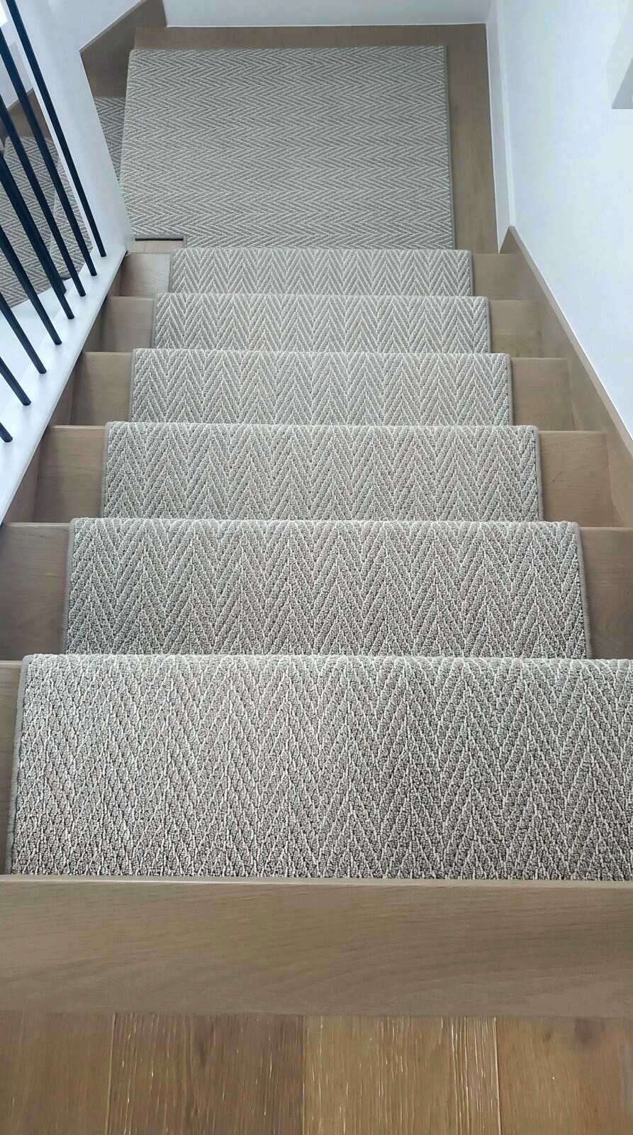 Herringbone stair runner on white oak stairs